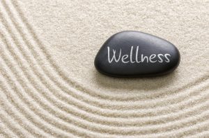 A black stone with the inscription Wellness